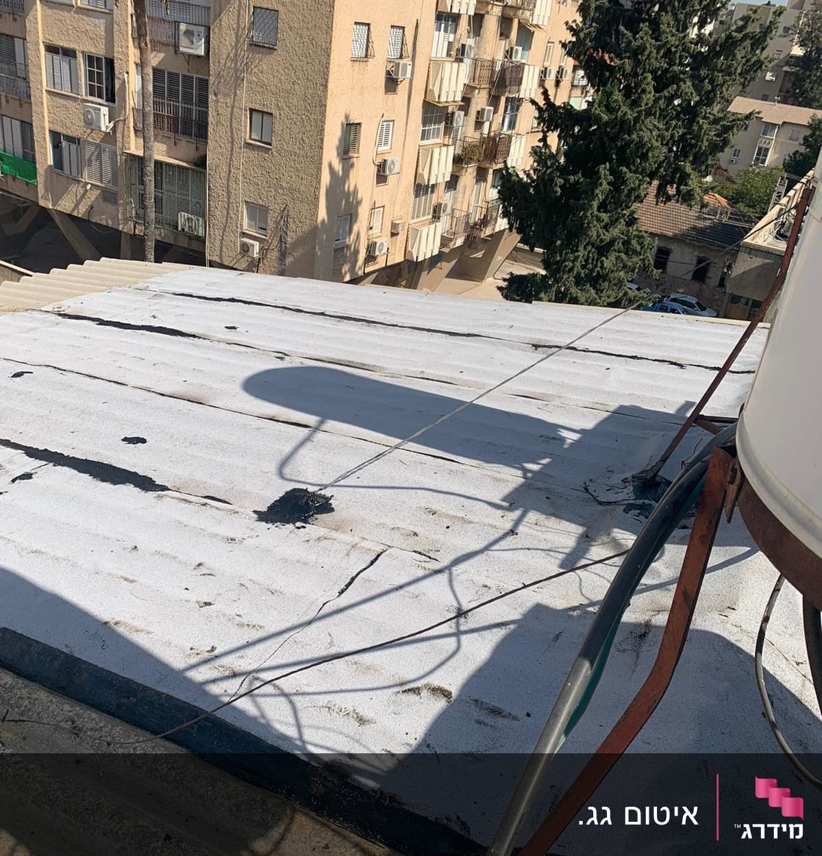 גג עם יריעות איטום לבנות וסדקים